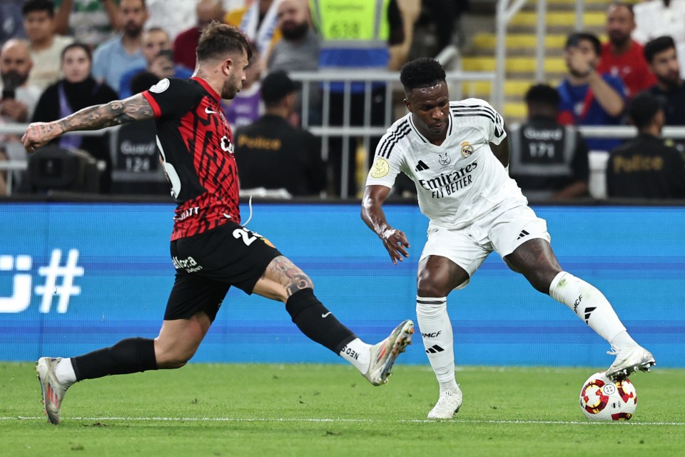 Pablo Maffeo and Vinicius Junior vying for the ball during a soccer match.