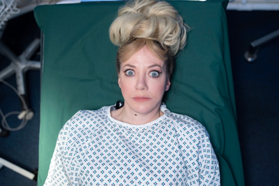 Woman in hospital gown lying on examination table with wide eyes.