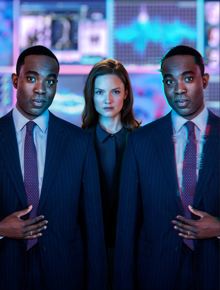 A woman flanked by two men in suits.