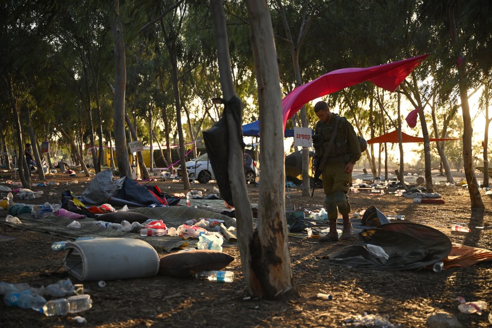 Israeli soldier searching through debris at a music festival site.