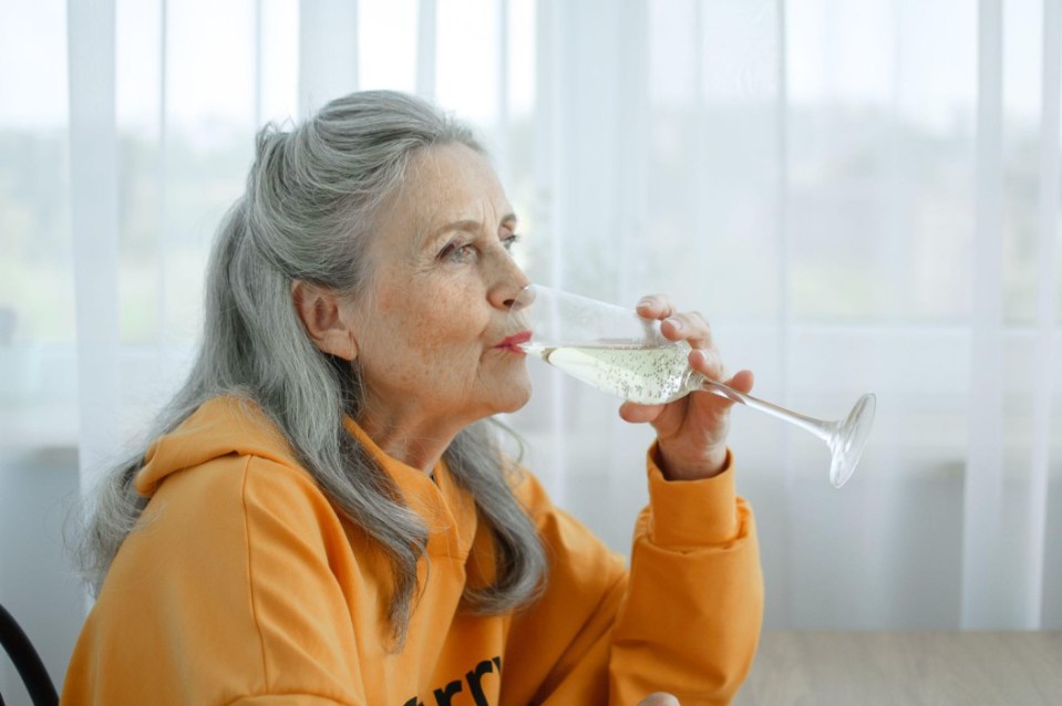 Older woman drinking champagne.