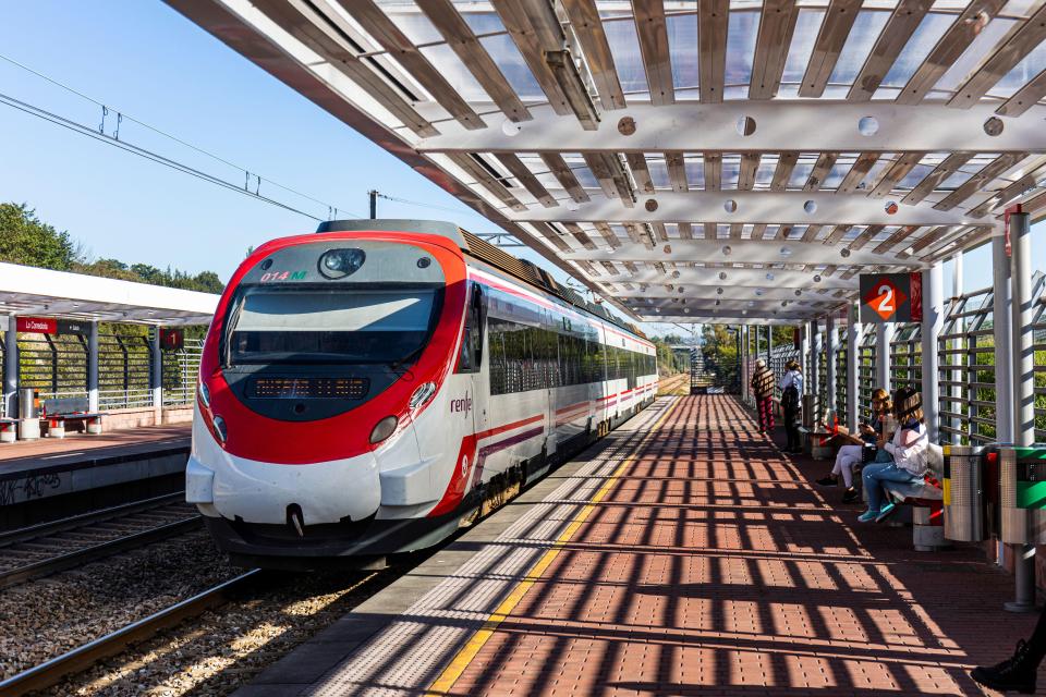 Modern commuter train arriving at a station platform.