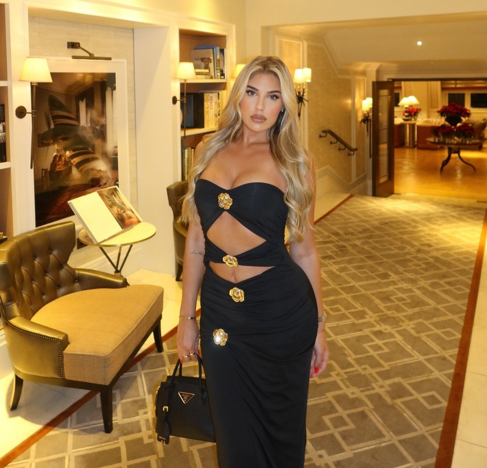 Anna Vakili in a black cutout dress in a hotel lobby.