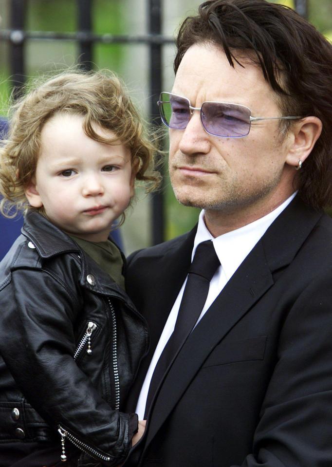 Bono holding his young son at his father's funeral.