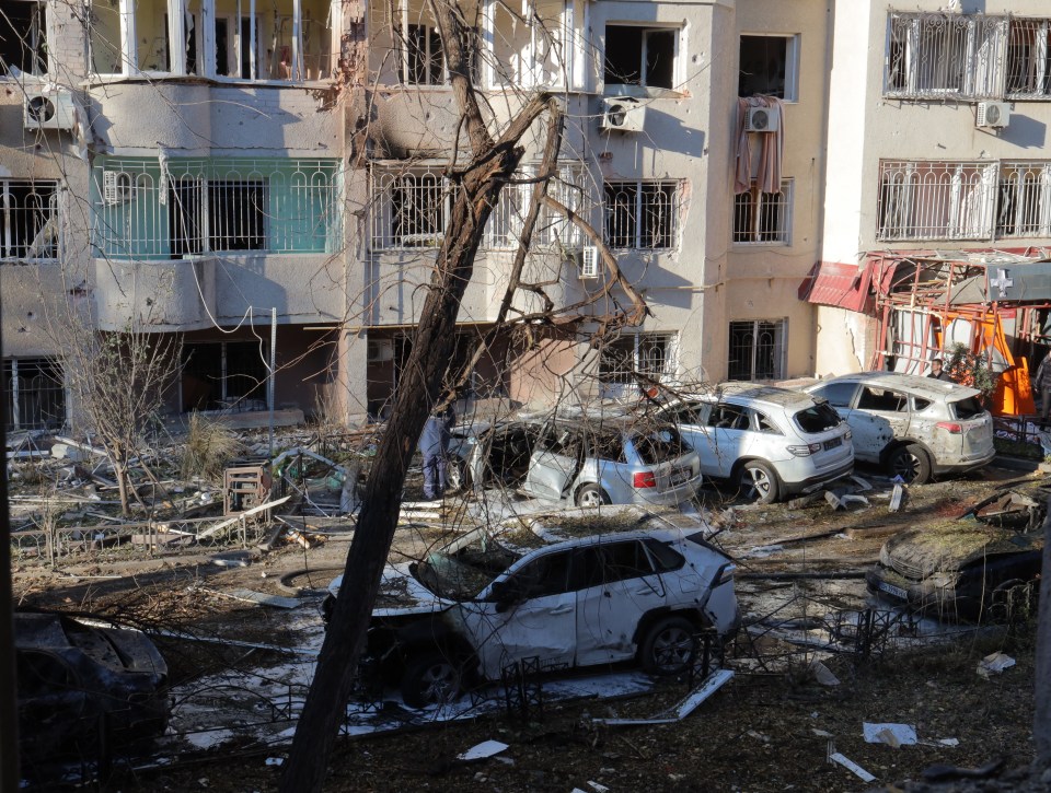 Damage to residential building and cars after a missile attack.