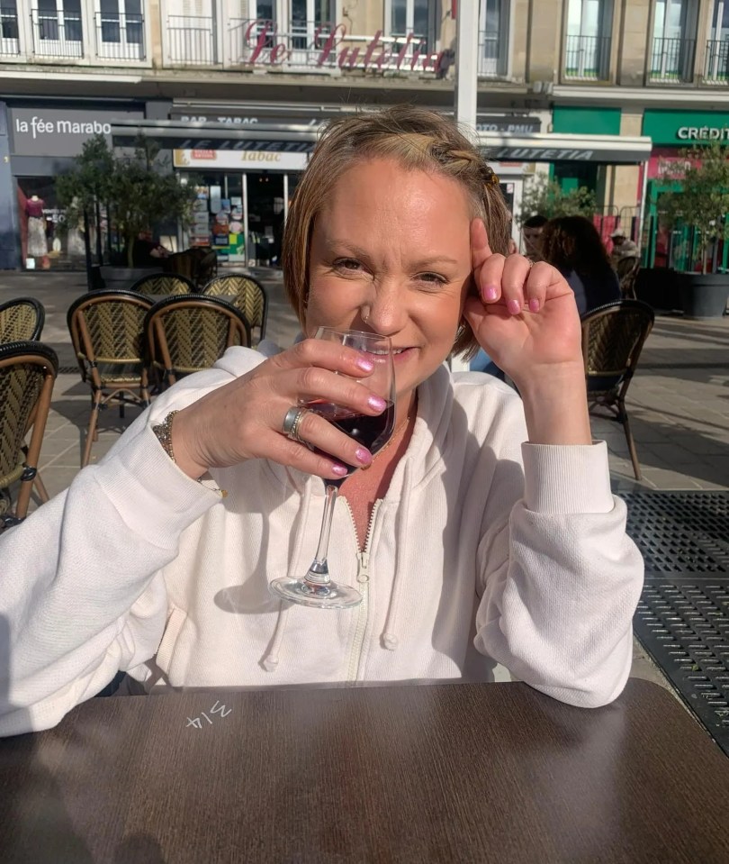 Woman drinking wine at an outdoor cafe.