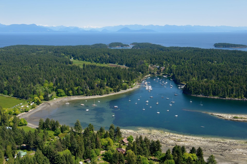 Aerial view of Degnen Bay, Gabriola Island, BC, showing a marina and surrounding forest.