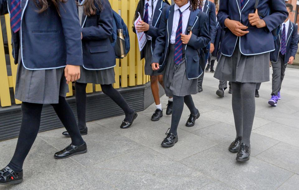 Anxious teenage girl in school uniform walking to school.