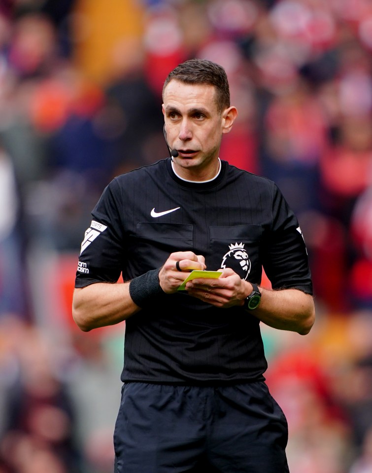 Referee David Coote writing on a yellow card.