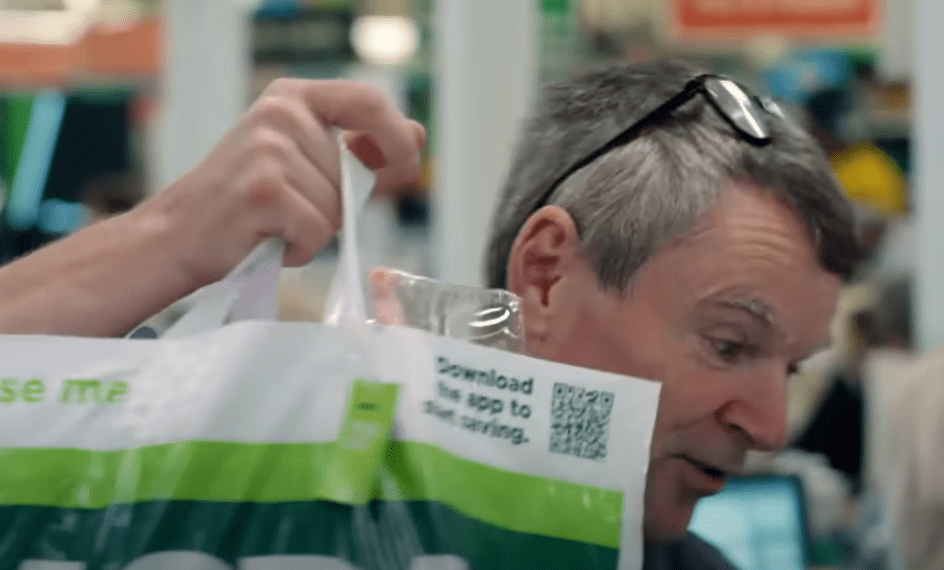 Man looking at an Asda shopping bag.