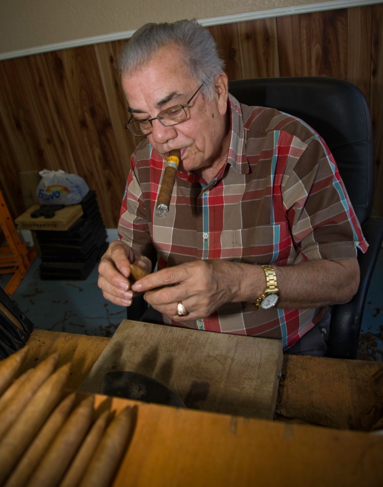 A man rolling a cigar.