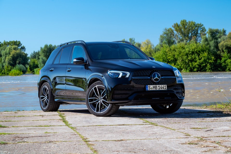 Black Mercedes-Benz GLE 350e PHEV parked by a river.