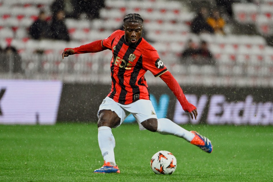 Issiaga Camara kicking a soccer ball during a rain-soaked match.