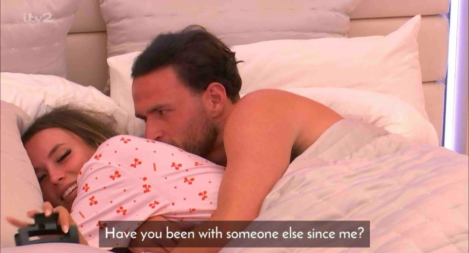 Screenshot of a man asking a woman in bed if she has been with anyone else since him.