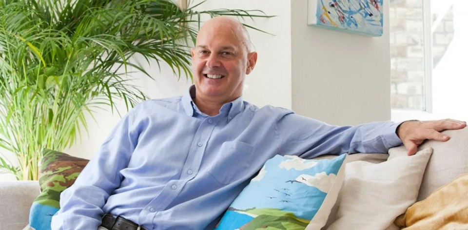 Man smiling while sitting on a couch.