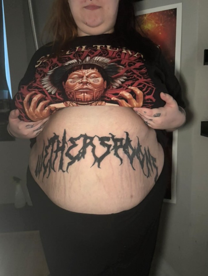 Person showing off a large Wetherspoon's tattoo on their stomach.