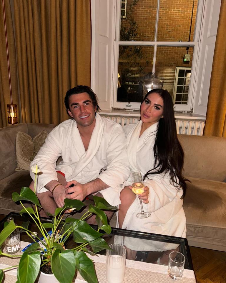 Couple in bathrobes relaxing with champagne.