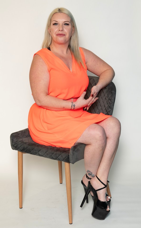 Woman in orange dress sitting on chair.