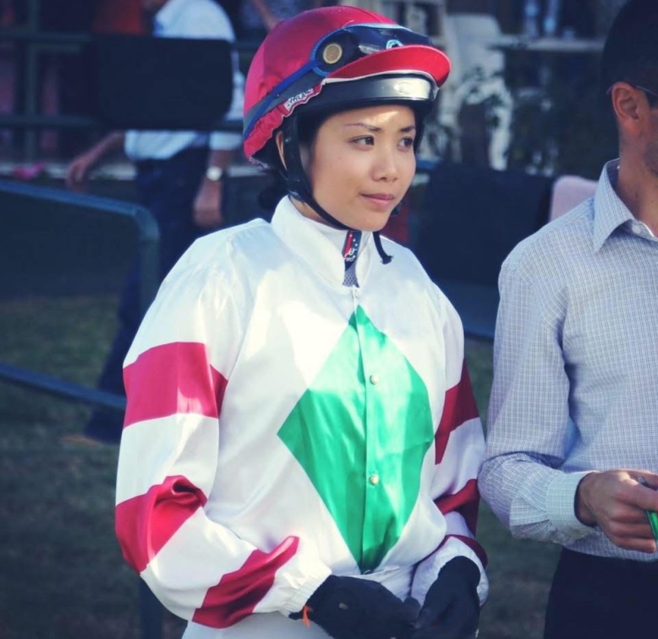 Female jockey in racing silks.