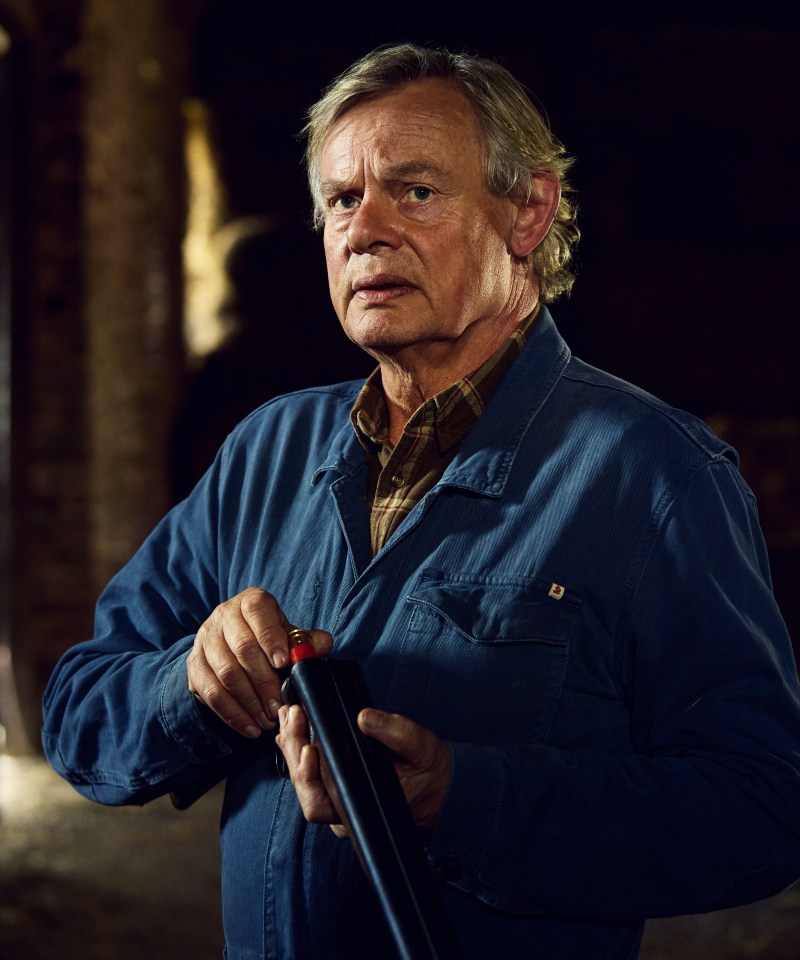 Martin Clunes as Nathan Williams loading a shotgun.