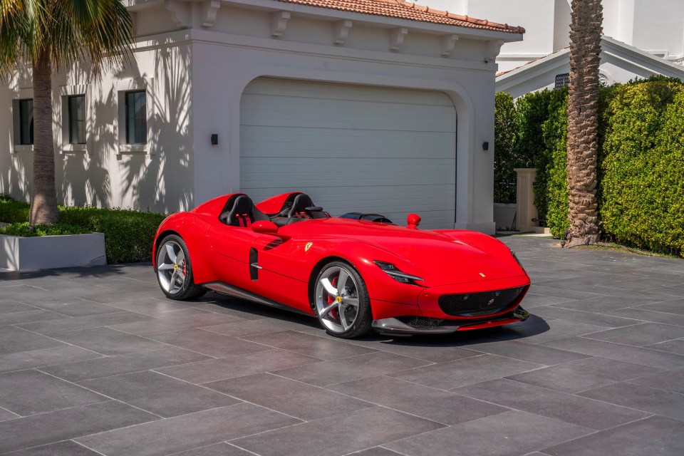 Red Ferrari Monza SP2 parked in a driveway.