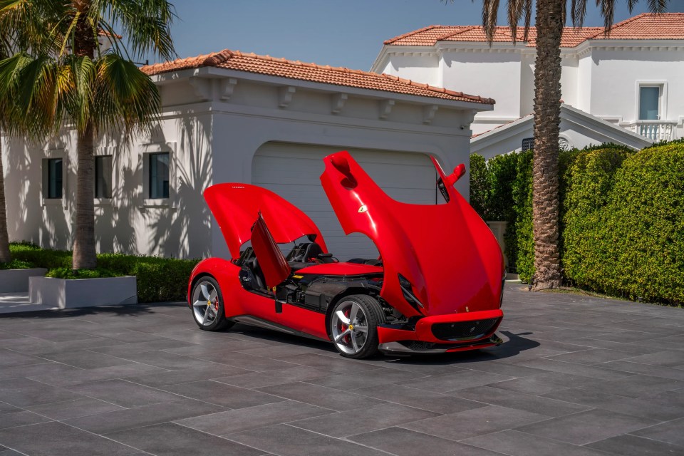 Red Ferrari Monza SP2 with butterfly doors open.