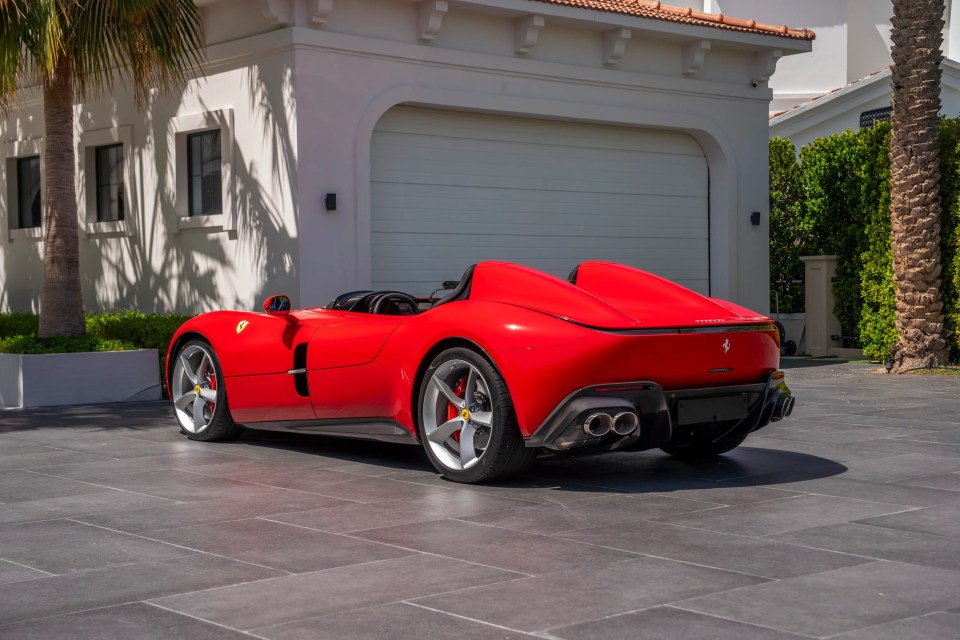 Red Ferrari Monza SP2 parked in a driveway.