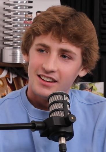 Young man speaking into a microphone during a podcast interview.