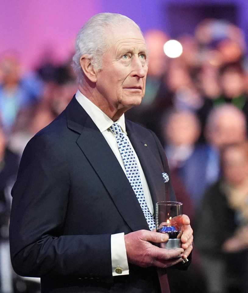 King Charles III holding a lit candle at Auschwitz-Birkenau.