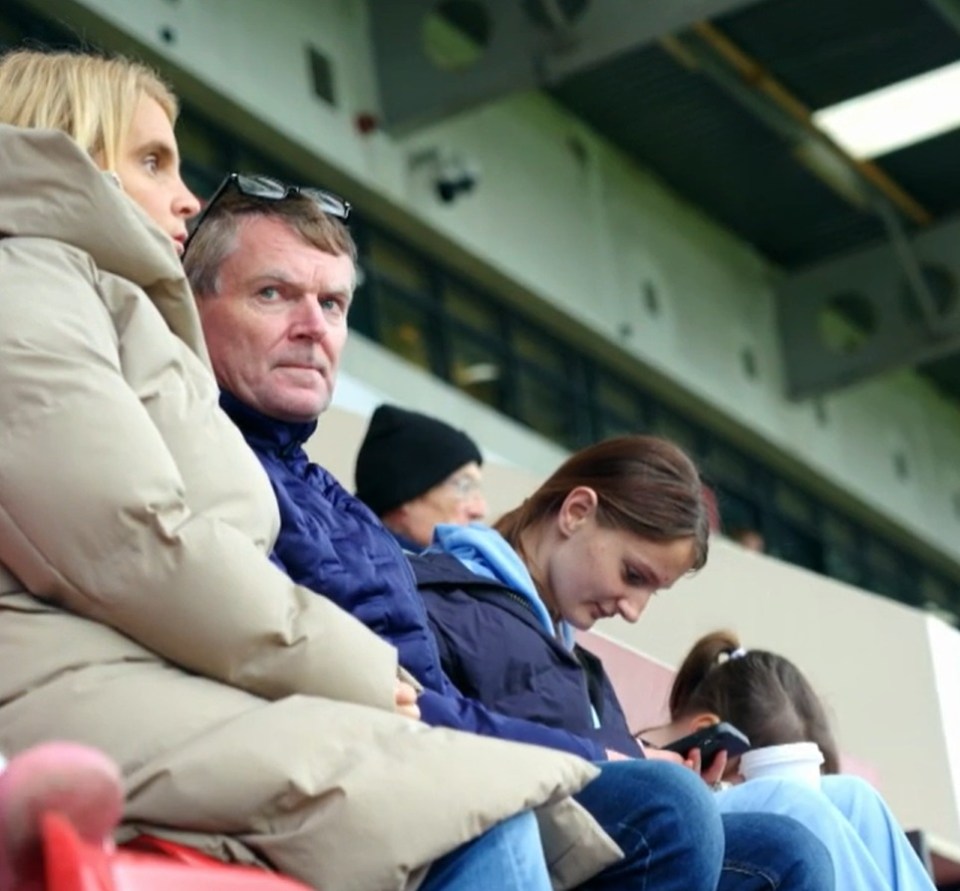 Screenshot of a family sitting in stadium seats.