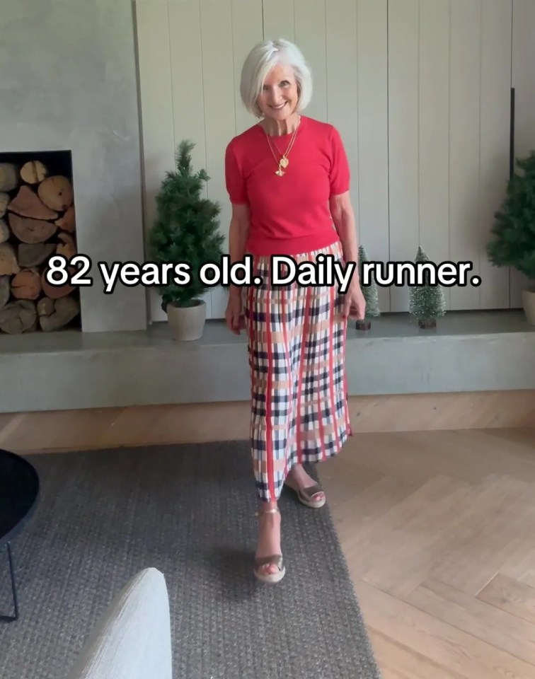 82-year-old woman in a red shirt and plaid skirt.