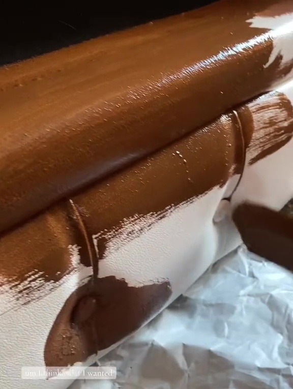 Brown paint being applied to a white sofa.