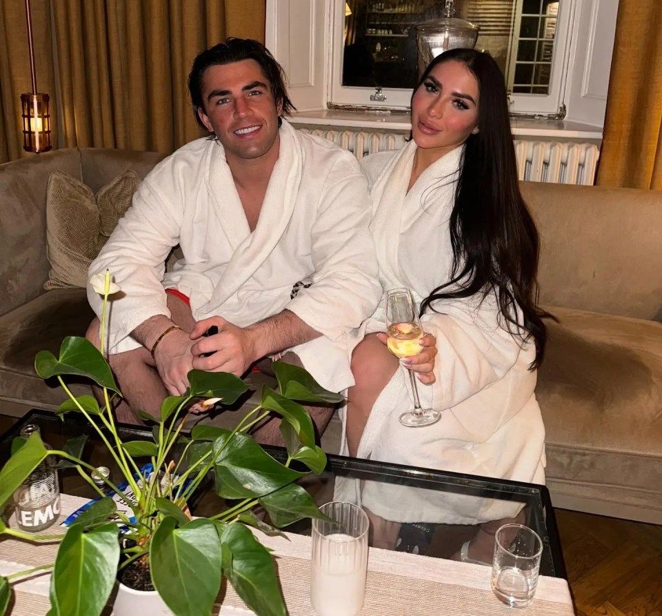 Couple in bathrobes relaxing with champagne.