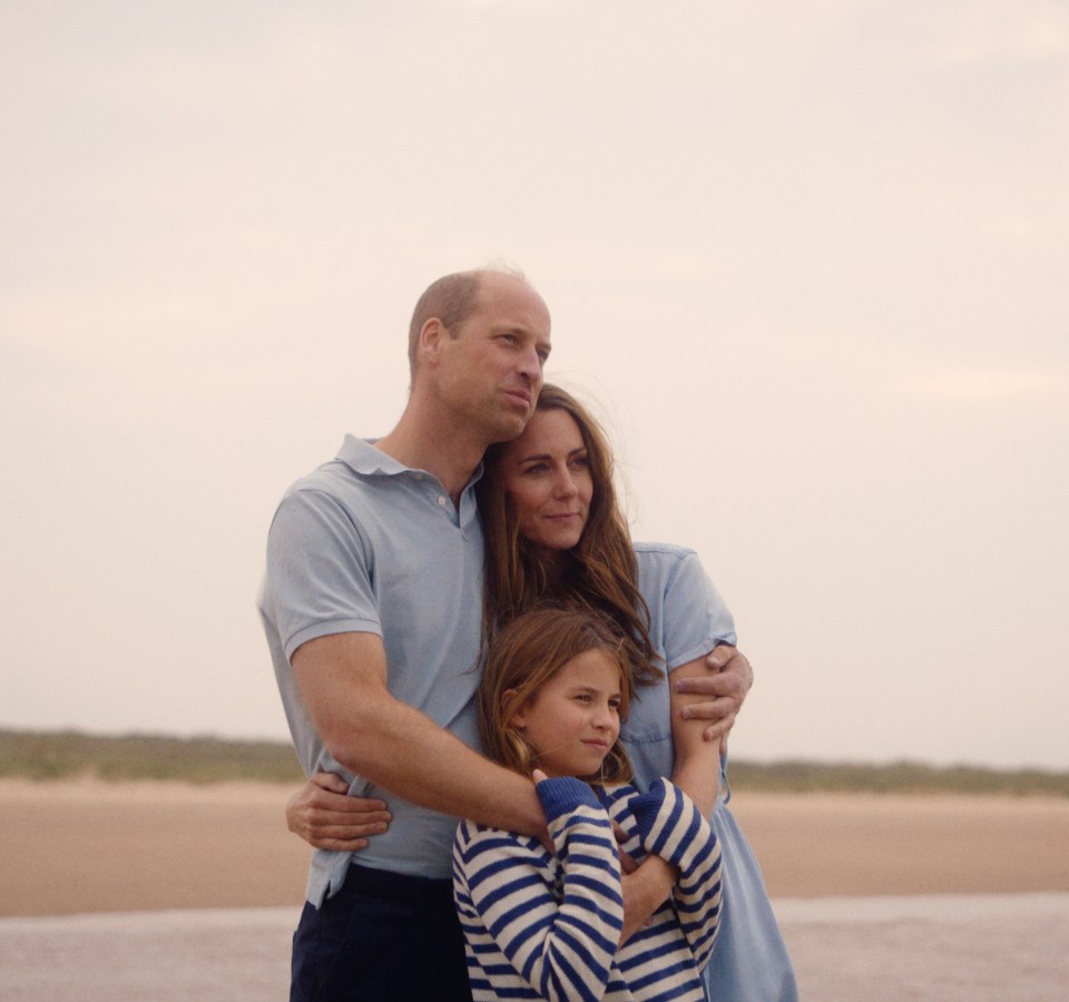 The Prince and Princess of Wales and Princess Charlotte on a beach.