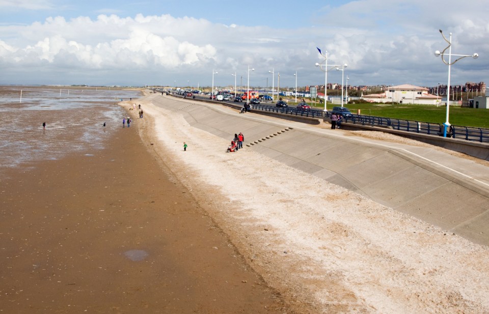 Southport beach and promenade with people walking.