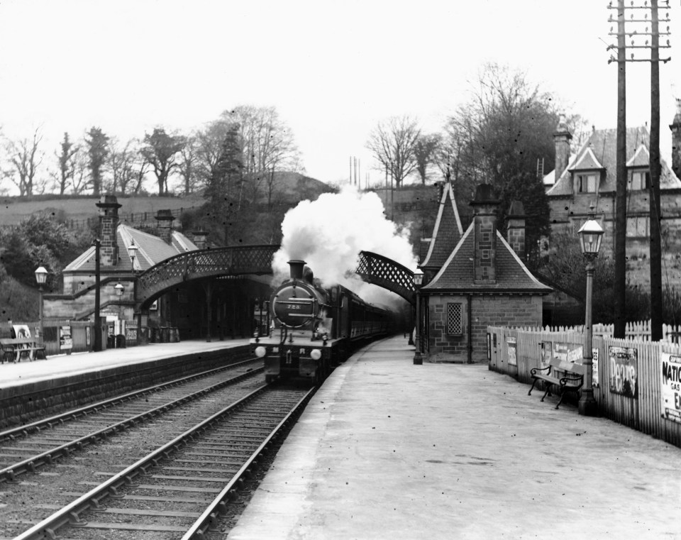 A steam train passes through Cromford Station in the Midlands.