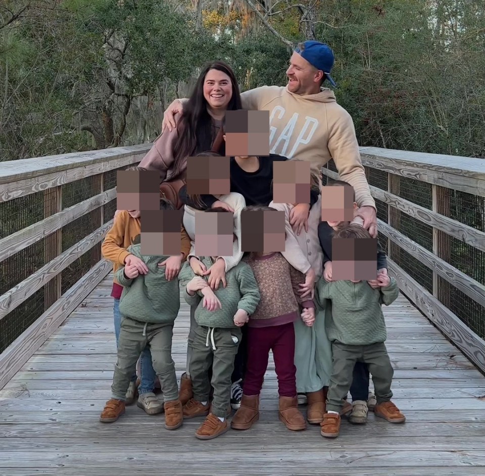 Family of eleven on a wooden walkway.