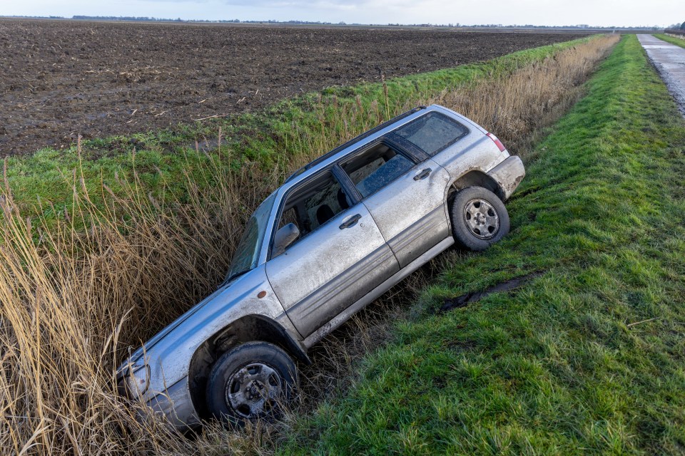 Mud-covered car in a ditch.