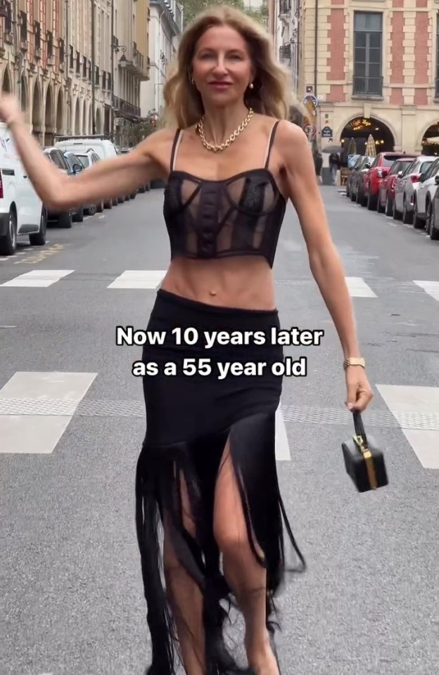 A 55-year-old woman in a black sheer top and fringed skirt walks down a Parisian street.