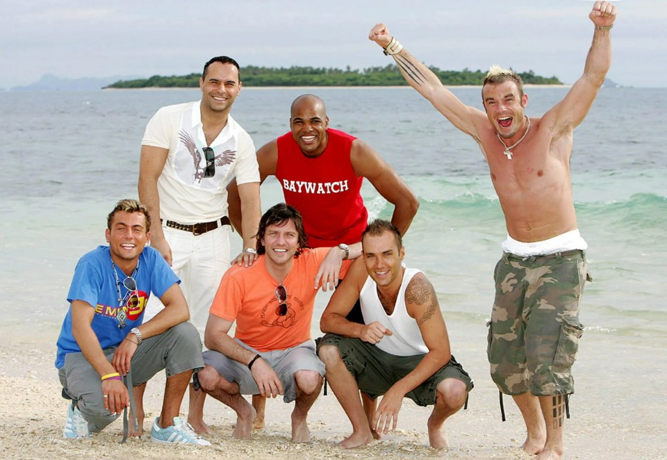 Photo of six men on a beach, participants in the Celebrity Love Island TV programme.