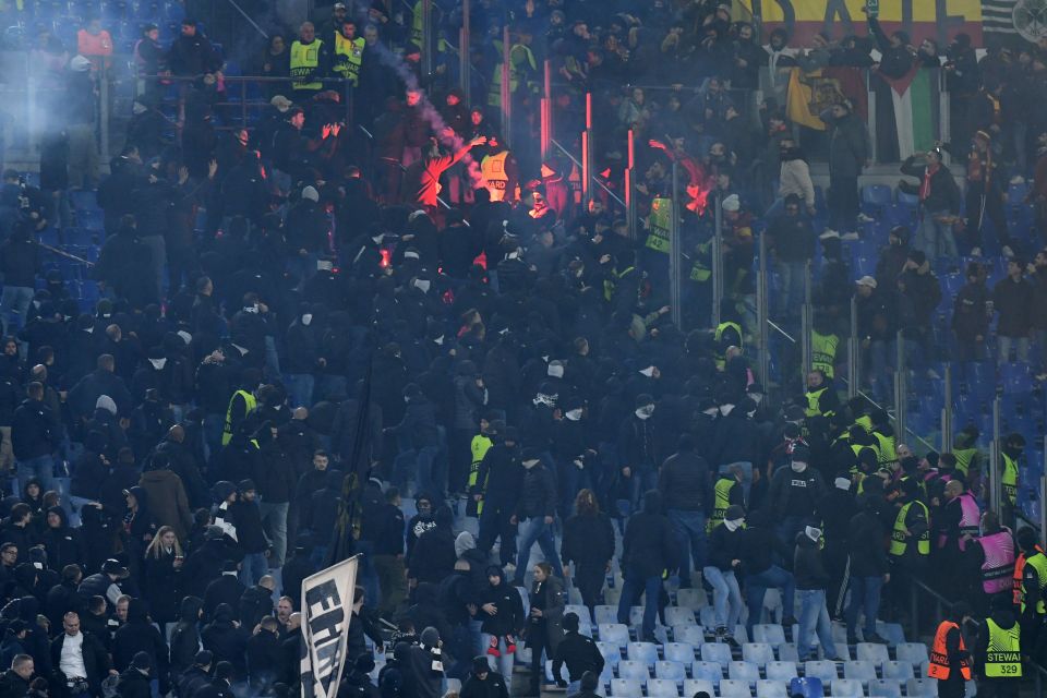 Eintracht Frankfurt fans clashing with security at a soccer match.