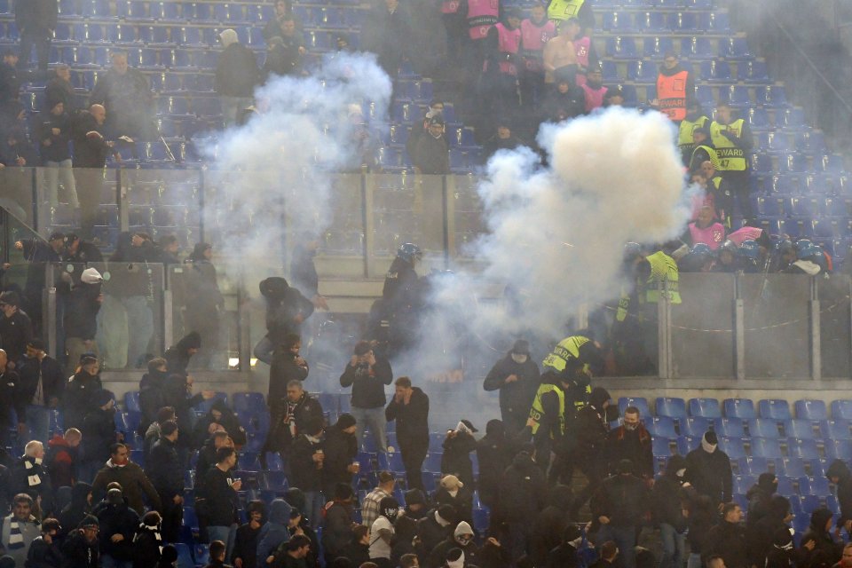 Smoke and commotion in a stadium during a soccer match.