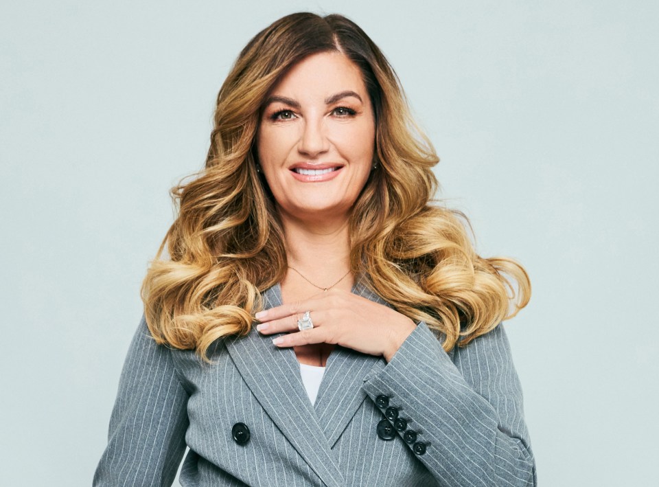 Portrait of Karren Brady in a gray pinstripe pantsuit.