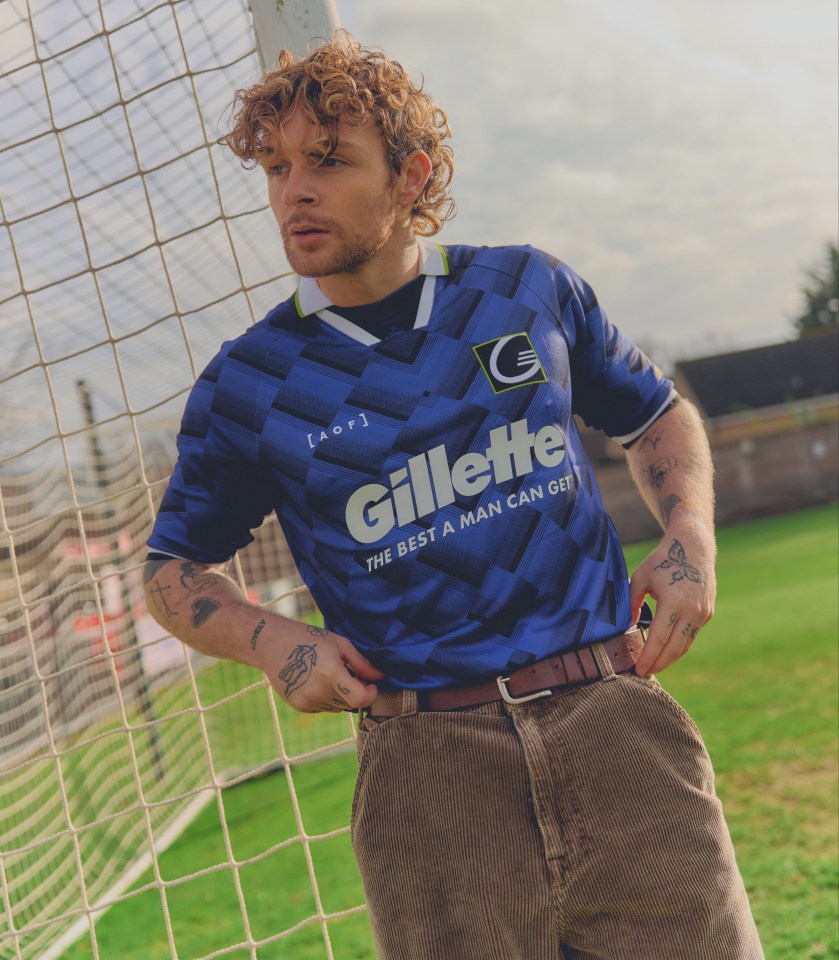 Tom Grennan wearing a blue charity football shirt.