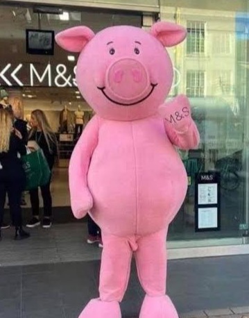 A pink pig mascot without pants standing outside an M&S store.