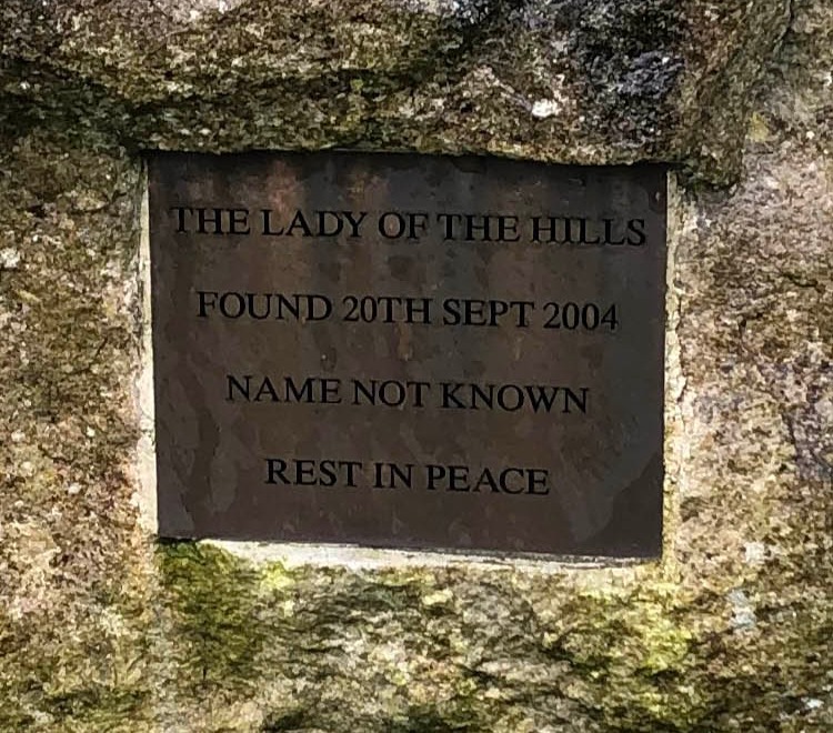 Memorial plaque on a rock: "The Lady of the Hills. Found 20th Sept 2004. Name not known. Rest in peace."