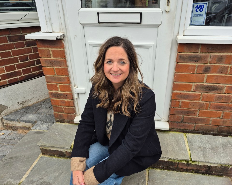 Woman sitting on steps outside a house.