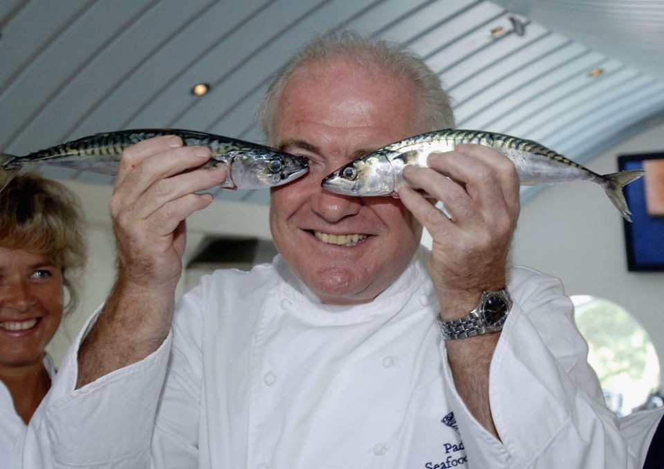 PADSTOW, ENGLAND - AUGUST 12: Celebrity chef Rick Stein poses with 16 invited school cooks, to learn new ways to cook fresh fish as part of the Cornish Healthy Schools Scheme, at Stein's Padstow Seafood School on August 12, 2005 in Padstow, England. The cooks learn how to make everything from mackerel fish cakes to pan fried fillets of gurnard in a drive similar to that of fellow chef Jamie Oliver, aiming to feed the country's children healthier meals. (Photo by Colin Shepherd/Getty Images)