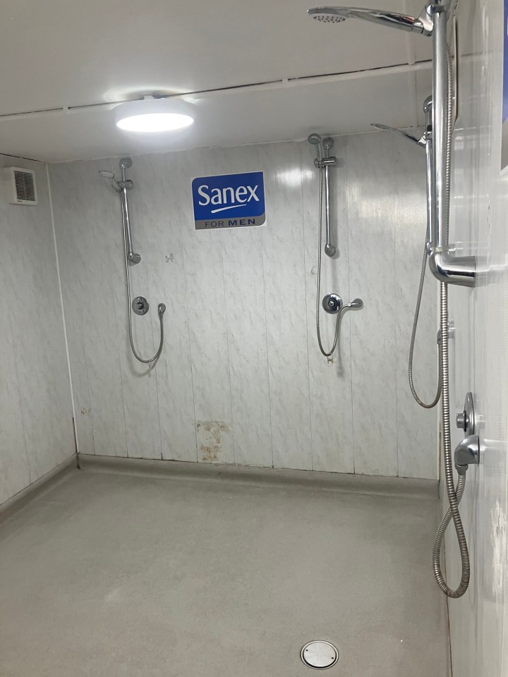 Two showers in a small room with a Sanex For Men sign.