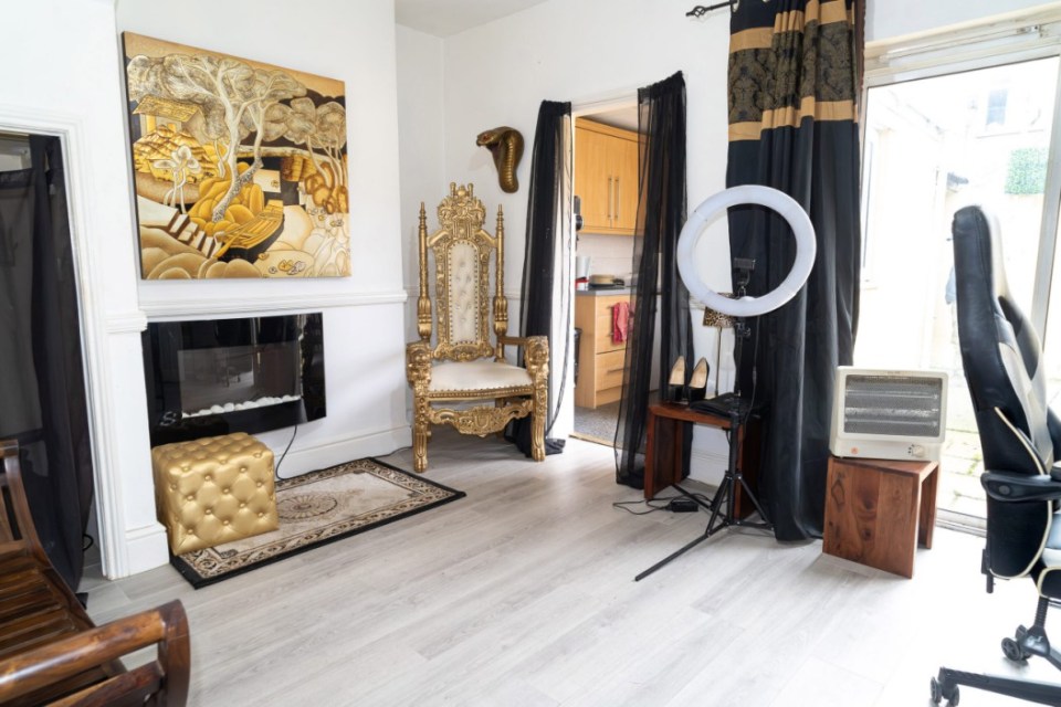 Interior of a house with a gold throne chair and a fireplace.